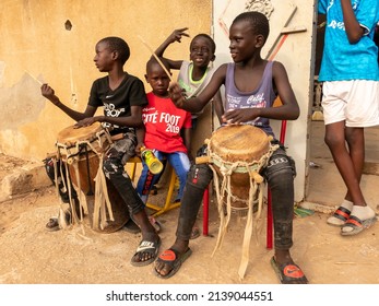 MBOUR, SENEGAL - DECEMBER Circa, 2021. Group Of Unidentified Child, Teenagers Street Performers Playing Music Drummer In The Village. Mainly Game For Poverty People In Africa