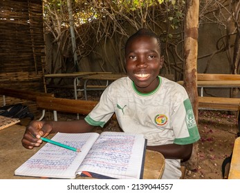 MBOUR, SENEGAL - DECEMBER Circa, 2021. Unidentified Young Child Writing Letter To Godfather Or Godmother Because European NGO Help Him To Pay School And Food For Family. Close-up On Hands