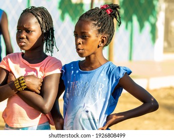 MBOUR, SENEGAL - JANUARY Circa, 2021. Portrait Of Unidentified Young Senegalese Children, Not Looking At Camera. Beautiful Skin, Hairs, Light. Outdoors