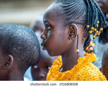 MBOUR, SENEGAL - JANUARY Circa, 2021. Portrait Of Unidentified Young Senegalese Children, Not Looking At Camera. Beautiful Skin, Hairs, Light. Outdoors