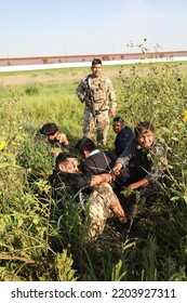 McAllen, TX, USA - Sept. 9, 2022: A Member Of The Texas National Guard Guards Five Mexican Men Who Were Apprehended After Crossing The Rio Grande River Illegally.