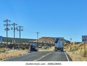 McCartys, New Mexico, USA - November 21, 2021: New Mexico State Police Officer Stands Sentry By The Side Of The Road In The Desert, As An Accident Near Grants, NM Has Caused A Severe Traffic Jam 