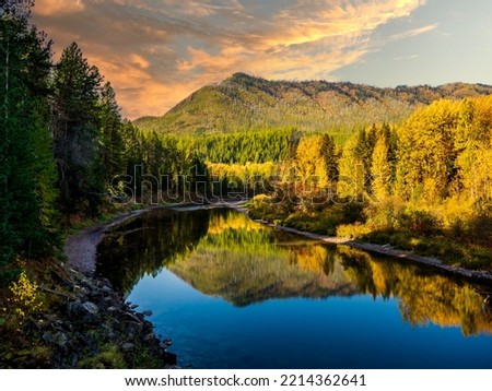 McDonald Creek in Glacier National Park as the sun lights up the autumn trees.