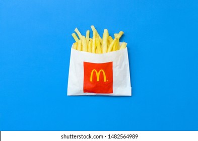 McDonald's French fries in small paperbag on bright blue background