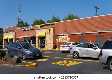 McDonald's Restaurant With Cars Line At Drive Thru At Sunny Day. Fast Food Place. Everett, WA, USA - October 2022