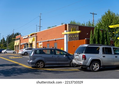 McDonald's Restaurant With Cars Line At Drive Thru At Sunny Day. Fast Food Place. Everett, WA, USA - October 2022