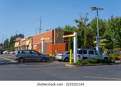 McDonald's Restaurant With Cars Line At Drive Thru At Sunny Day. Fast Food Place. Everett, WA, USA - October 2022