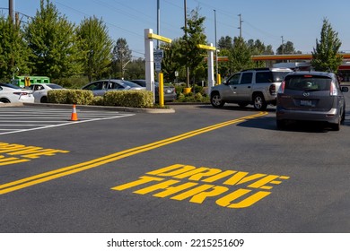 McDonald's Restaurant With Cars Line At Drive Thru At Sunny Day. Fast Food Place. Everett, WA, USA - October 2022