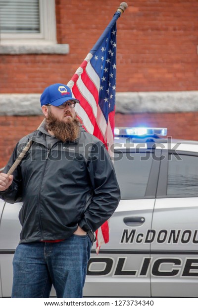 McDonough, GA / USA -
January 3, 2019:  A man holds a U.S. flag during the funeral
procession for Officer Michael Smith, who was shot on Dec. 6, 2018
and died three weeks
later.