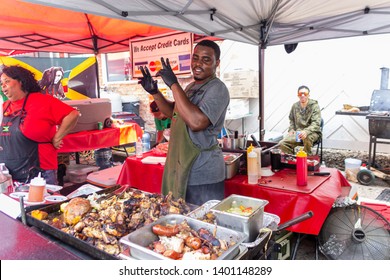 McDonough, Georgia / USA - May 18, 2019: A Food Vendor Gestures For The Photographer While Cooking At The 42nd Annual Geranium Festival.