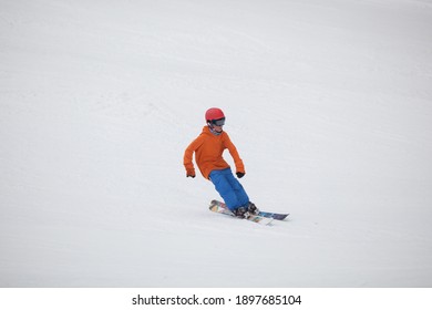 MCHENRY, MD, UNITED STATES - Feb 24, 2013: A young skier on the ski slope in a colorful orange and blue ski outfit at the Maryland Open Ski Competition at the Wisp Ski Resort 