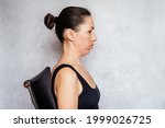 McKenzie method exercise to relieve neck pain, a woman is holding her head in the retracted position while doing neck pain relief exercises