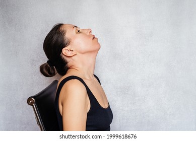 McKenzie Method Exercise To Relieve Neck Pain, A Woman Gently Rotates Her Head While Doing Neck Pain Relief Exercises