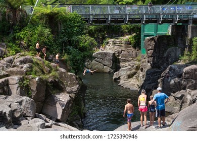 McLaren Falls, Lower Kaimai / New Zealand - January 27, 2018: People And Friends On Cliff Rock Diving To Lake Water