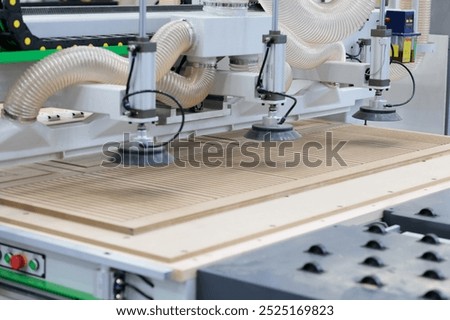 MDF panel carving and cutting using CNC router with a vacuum table. Selective focus.