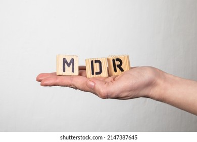 MDR Medical Device Regulation. Wooden Letters In A Woman's Hand.