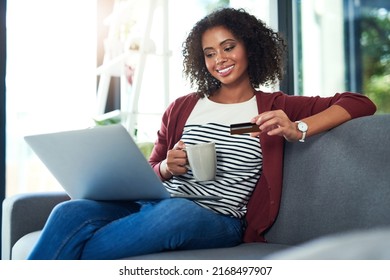 Me Time Is Treat Time. Shot Of A Young Woman Using A Laptop And Credit Card On The Sofa At Home.