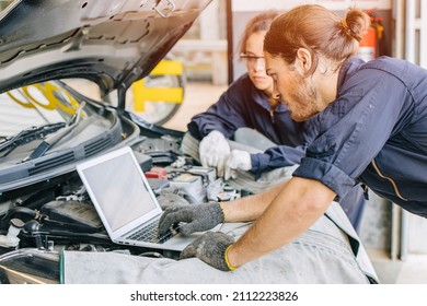 Meachnic Staff Worker Using Laptop Computer Check Ane Tuning Car Engine In Garage