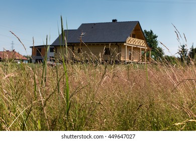 Meadow With Tall Grass Around A Wooden House