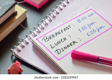 Meal Frequency Concept For Weight Loss And Diet. Three Meals A Day And It's Ideal Time List Handwritten On Notepad On Desk. Selective Focus.