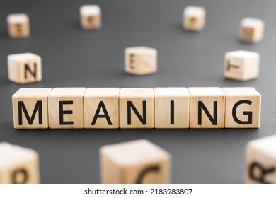 Meaning - word from wooden blocks with letters, Meaning sense, point, significance, value concept, random letters around black background - Shutterstock ID 2183983807