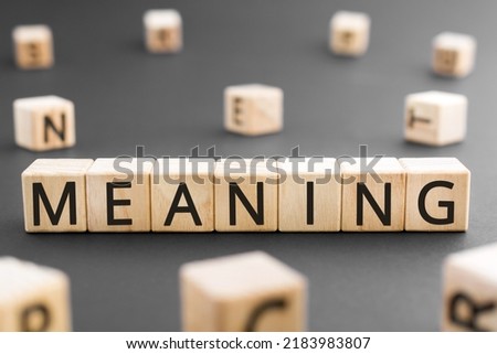 Meaning - word from wooden blocks with letters, Meaning sense, point, significance, value concept, random letters around black background