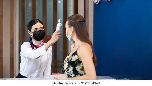 measure body temperature. receptionists working at a reception desk. People wearing protective face mask prevent covid-19 virus  - Powered by Shutterstock