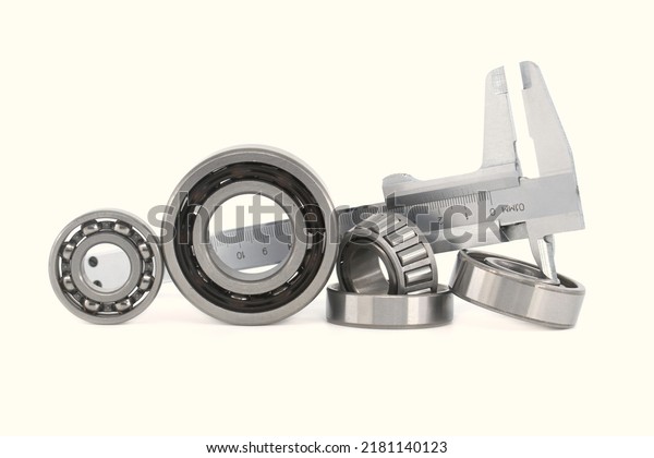 Measure caliper and\
roller bearings on white background. Mechanical engineering and\
automotive industry