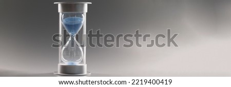 Measure passing time, countdown, blue sand running through bulbs of hourglass