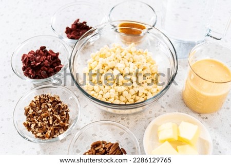 Measured ingredients in glass mixing bowls to make white chocolate cranberry pecan fudge.