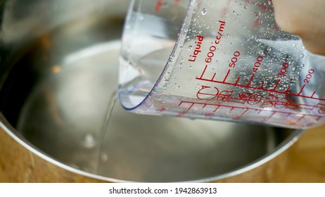 Measurement Cup Or Measurement Jug Is Usually Used To Measure Liquid Ingredients Like Water, Milk, Oil. 

In Frame Measurement Cup Pouring Water Into A Pan