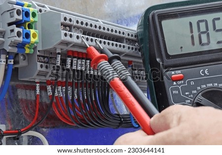 Measurement of electrical parameters in a switchboard using a digital multimeter.