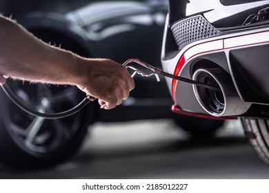 Measurement of exhaust emissions at the technical inspection station. A car repairman applies a probe to the exhaust. - Shutterstock ID 2185012227