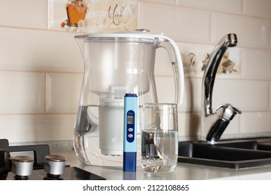 Measurement Of TDS Of Water. Electronic PH Meter In A Glass Of Water.Filter For Water Purification. There Is A Tap For Drinking Water In The Background. (translation:Honey, I )