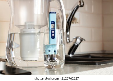 Measurement Of TDS Of Water. Electronic PH Meter In A Glass Of Water.Filter For Water Purification. There Is A Tap For Drinking Water In The Background. 