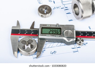 Measurement Of Thread Cutting Die By Calipers And Technical Drawing. Metal Engineering Parts And The Digital Measuring Tool Placed On The Manufacturing Documentation.