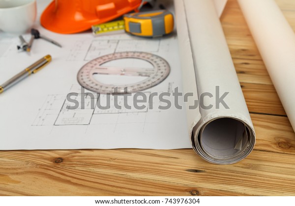 Measurement tool with helmet and coffee on\
blueprint, architectural\
concept