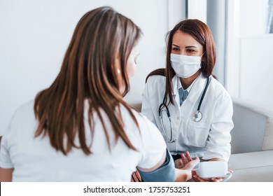 Messung des Blutdrucks. Junge Frau besucht in einer modernen Klinik eine Ärztin.