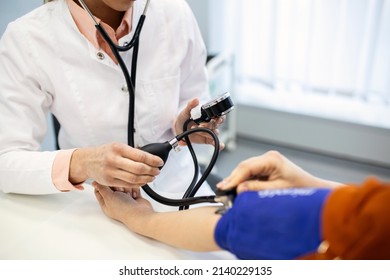 Measuring Blood Pressure. Young Woman Have A Visit With Female Doctor In Modern Clinic. Measuring Blood Pressure. Pressure Gauge. Hypertension And High Heart Rate