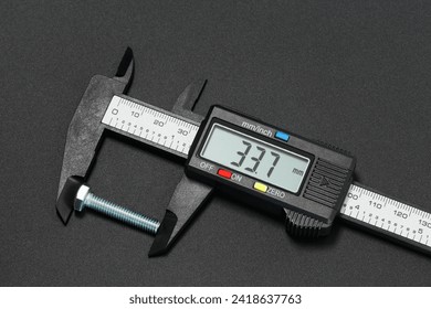 Measuring bolt length using a digital caliper. Macro photography on a dark background - Powered by Shutterstock