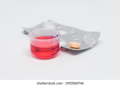 Measuring Cup For Syrup, Cough Syrup, Medicine, Red Syrup In Cup, Pill Tablet, Medicine, Self-medication, White Background