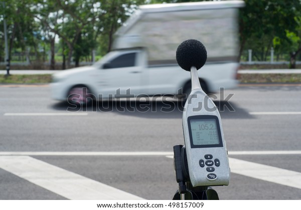 Measuring the noise of cars on the road with a\
sound level meter.