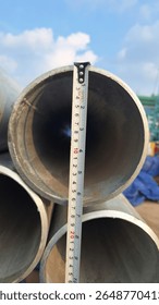 Measuring Pipe Diameter with Tape at Construction site