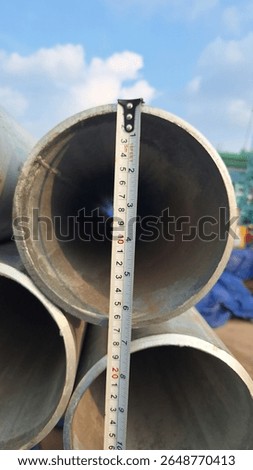 Measuring Pipe Diameter with Tape at Construction site