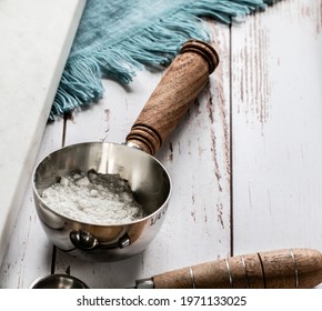 Measuring Spoon With White Ingredient Maybe Flour Sugar Or Powdered Sugar On A Table With A Blue Cloth And Natural Light