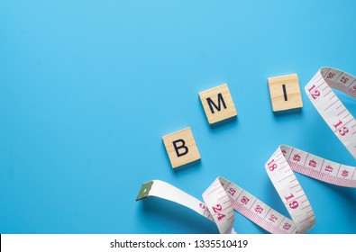 Measuring Tape And BMI Word In Wooden Block On Blue Back From To