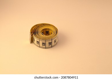 Measuring tape. Close up and isolated against a white background. Rolled up and tight. The metric system with centimeters. 