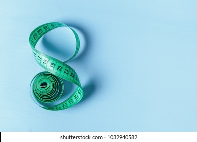 Measuring tape in the form of eight on a blue background - Shutterstock ID 1032940582