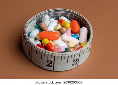 A measuring tape forms a circular container filled with a variety of colorful pills and capsules. Diet pills, weight loss supplements, and medical dosage control concepts.
