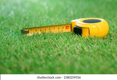 Measuring Tape Lies On The Artificial Grass Lawn